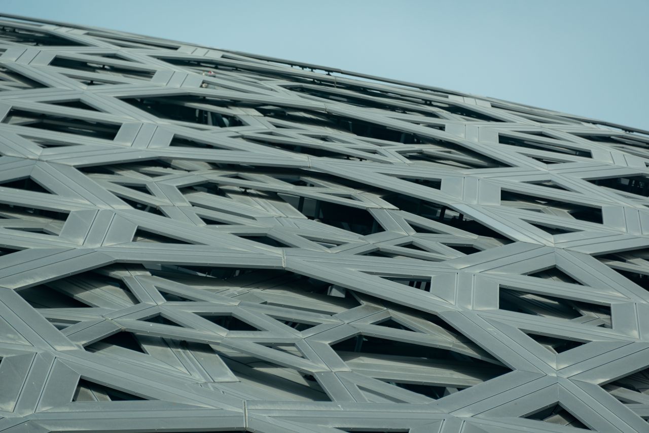 Low angle view of an intricate geometric steel facade with contemporary architectural design.